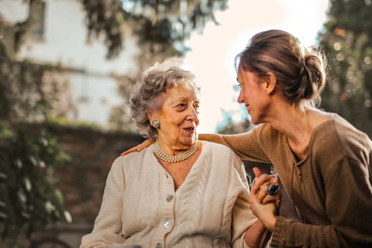 A caregiver sharing a warm, reassuring moment with an older woman